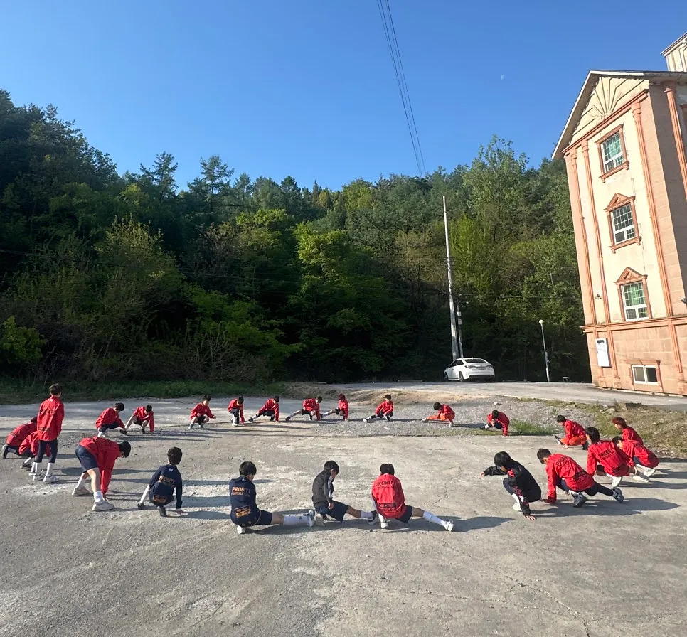 FC Probity players stretching together in a circle at an away training camp